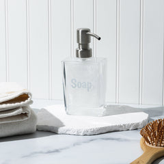 Soap dispenser in bathroom with towels