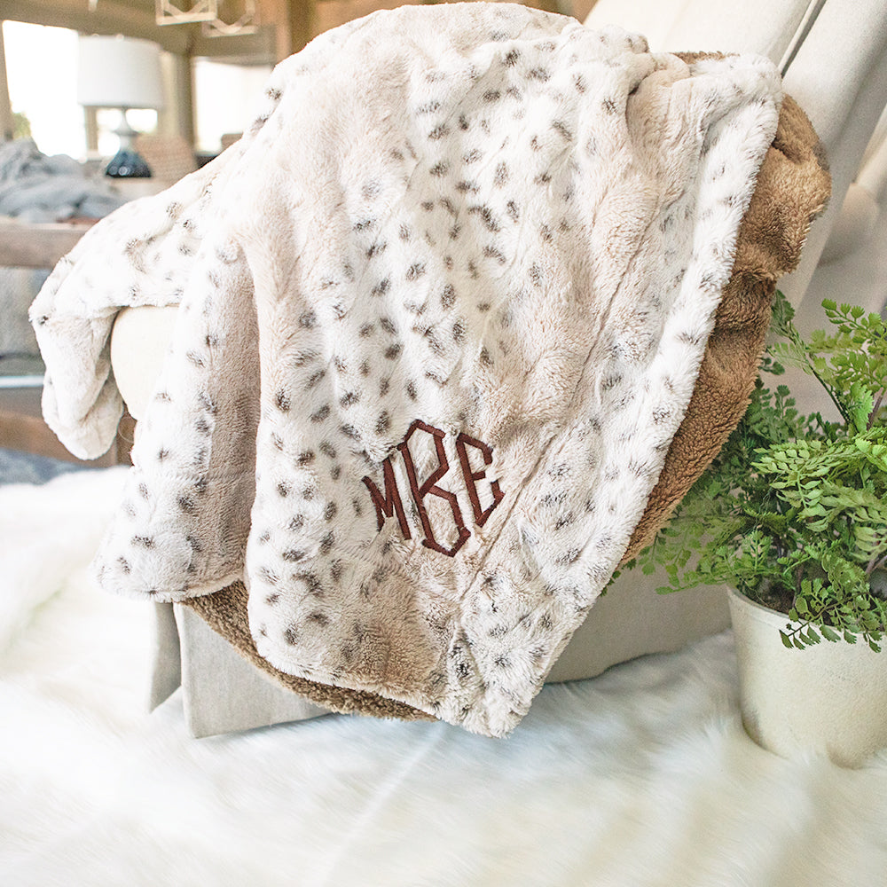 monogrammed khaki fuzzy blanket on couch