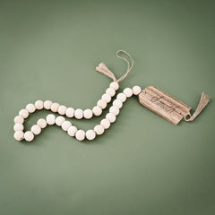 monogrammed wood bead garland on green background