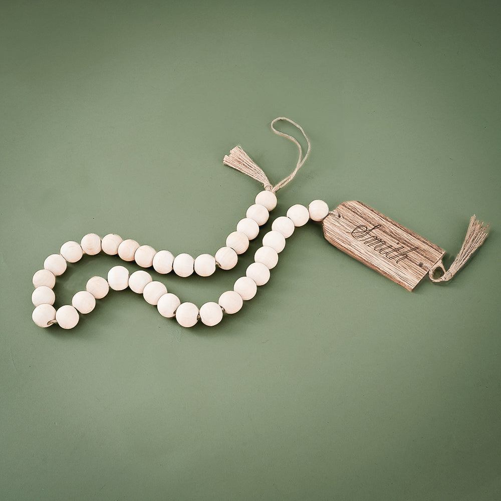 monogrammed wood bead garland on green background