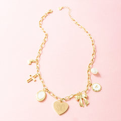 gold charm necklace on pink background