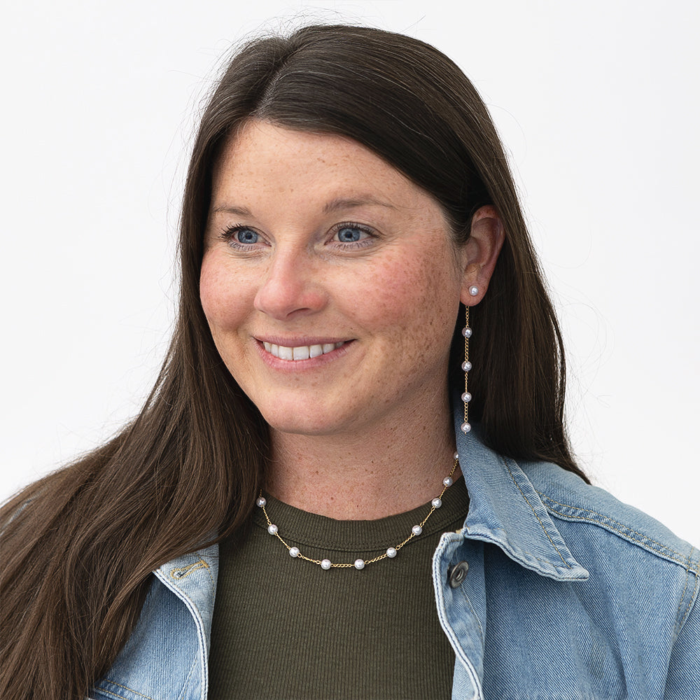 girl wearing pearl station necklace and earrings