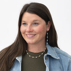 girl wearing pearl station necklace and earrings