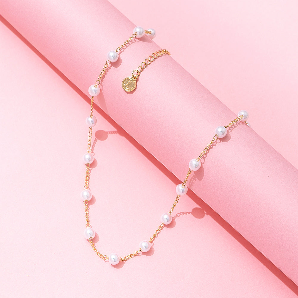 pearl station necklace on pink