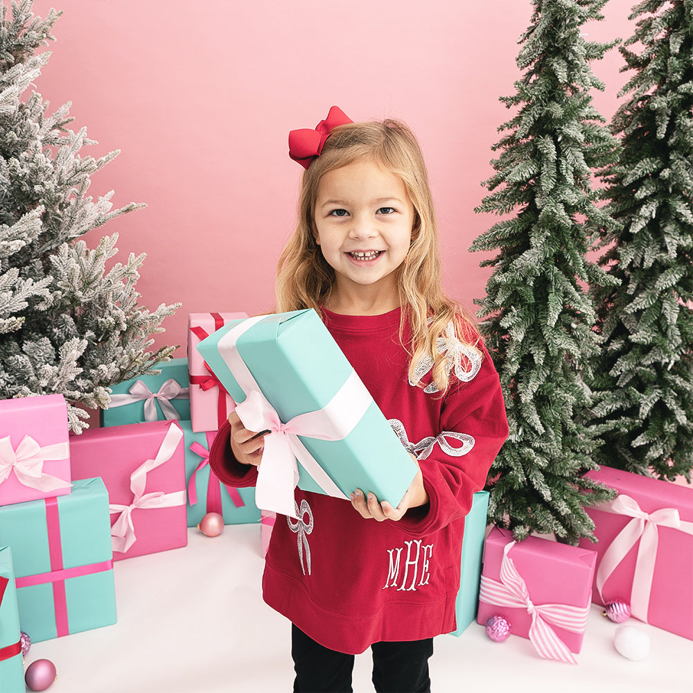 crimson kids sequin bow sweatshirt on girl with present