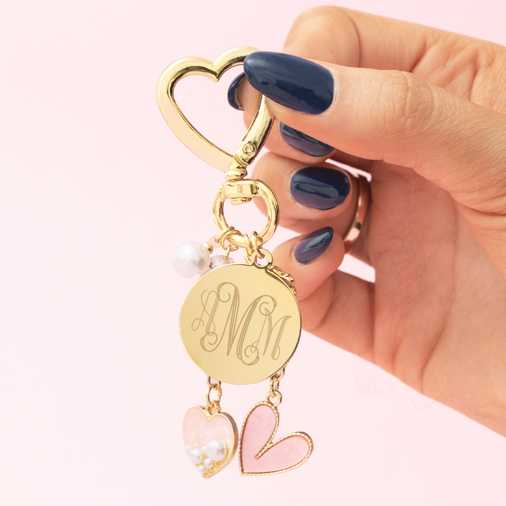 monogrammed gold bag charm keychain in hands