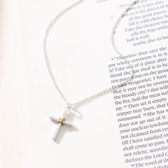 cable cross necklace on paper