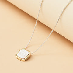 gold and silver cable pendant necklace with tan background