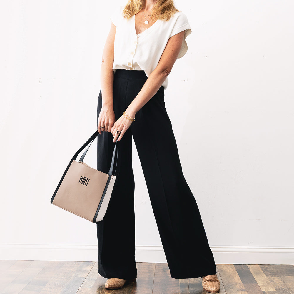 girl holding monogrammed shoulder tote in tan