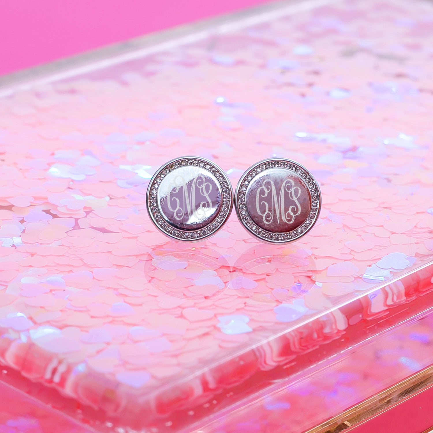 silver personalized disc earrings on glitter clutch