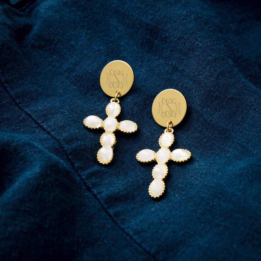 monogrammed cross earrings. on dark denim