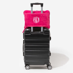 monogrammed travel blanket pillow in hot pink on suitcase
