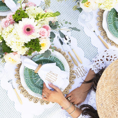 white scalloped placemat table with hands