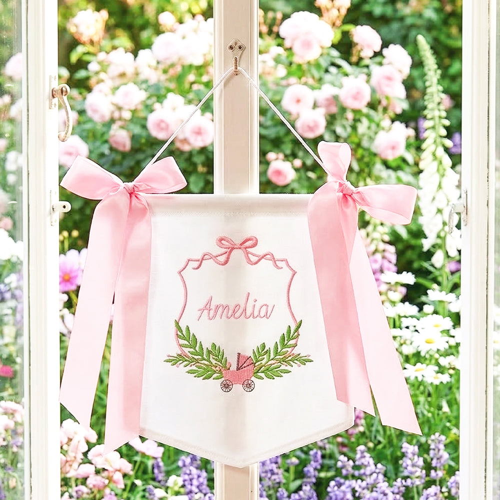 pink new baby banner on window