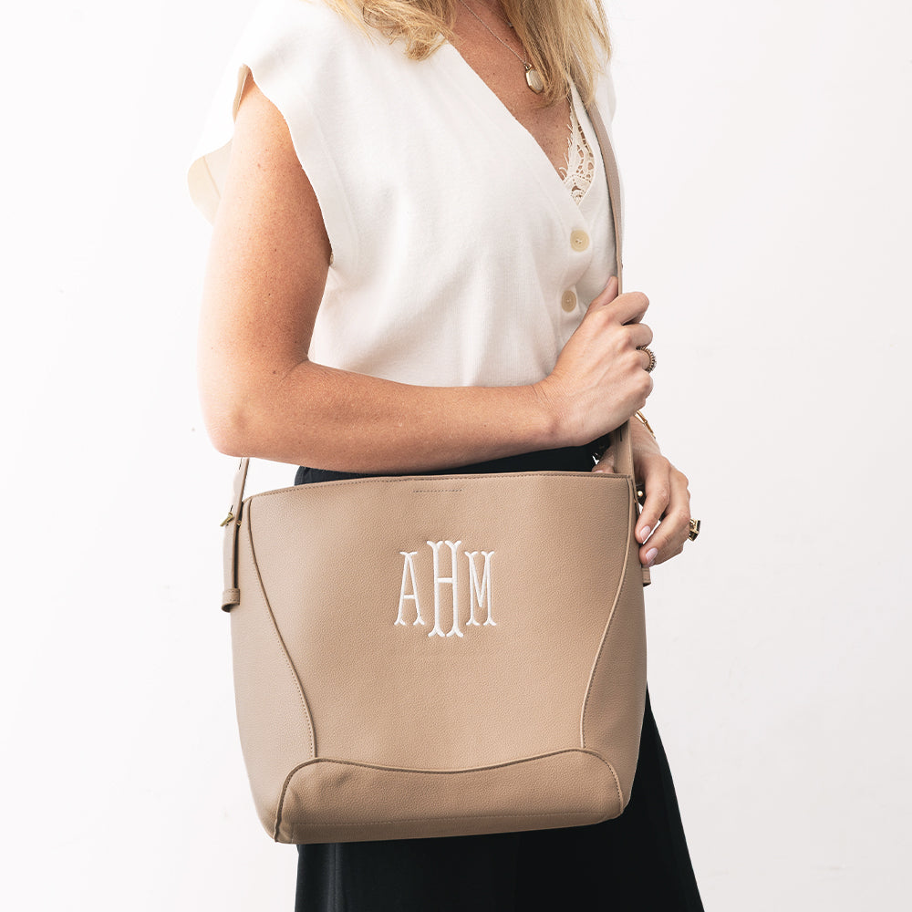 girl with monogrammed bucket bag in taupe