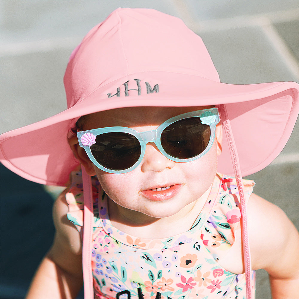 baby girl with pink sun hat and sunglasses