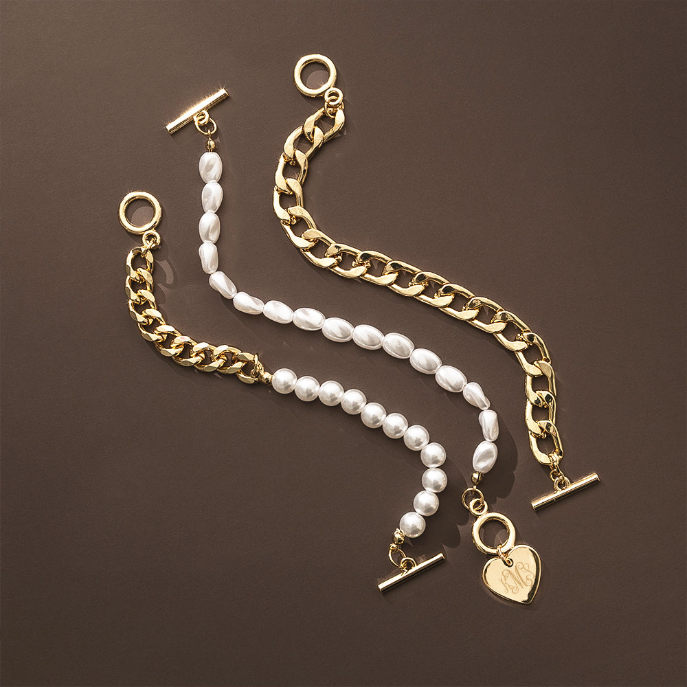 Gold chain and pearl bracelet with heart charm on a brown background