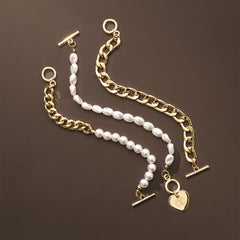Gold chain and pearl bracelet with heart charm on a brown background