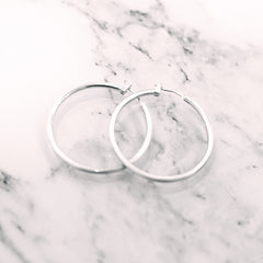 silver featherweight hoops on marble