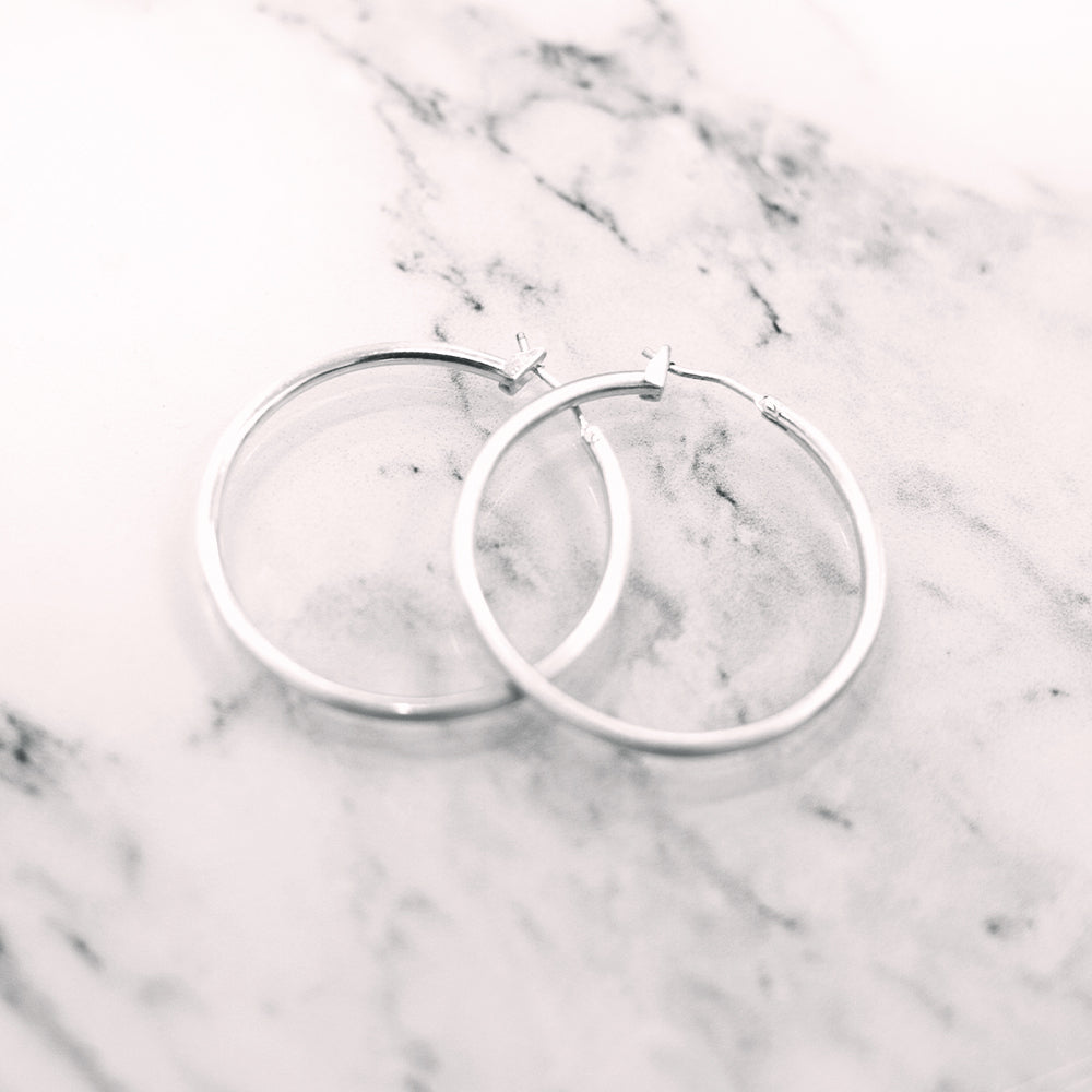 silver featherweight hoops on marble