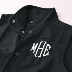 close up of buttons on black monogrammed sweatshirt vest