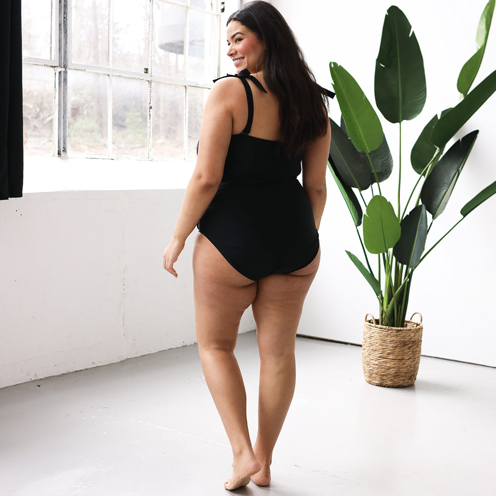 back of black monogrammed one piece bathing suit showing coverage