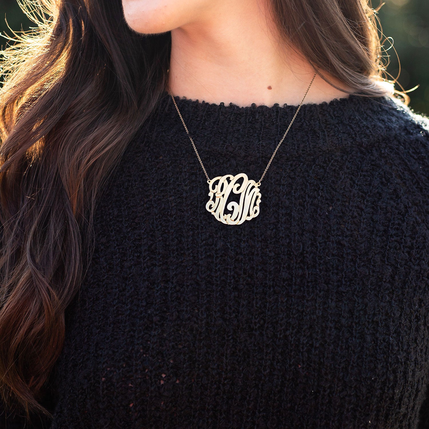 gold signature necklace with black sweater