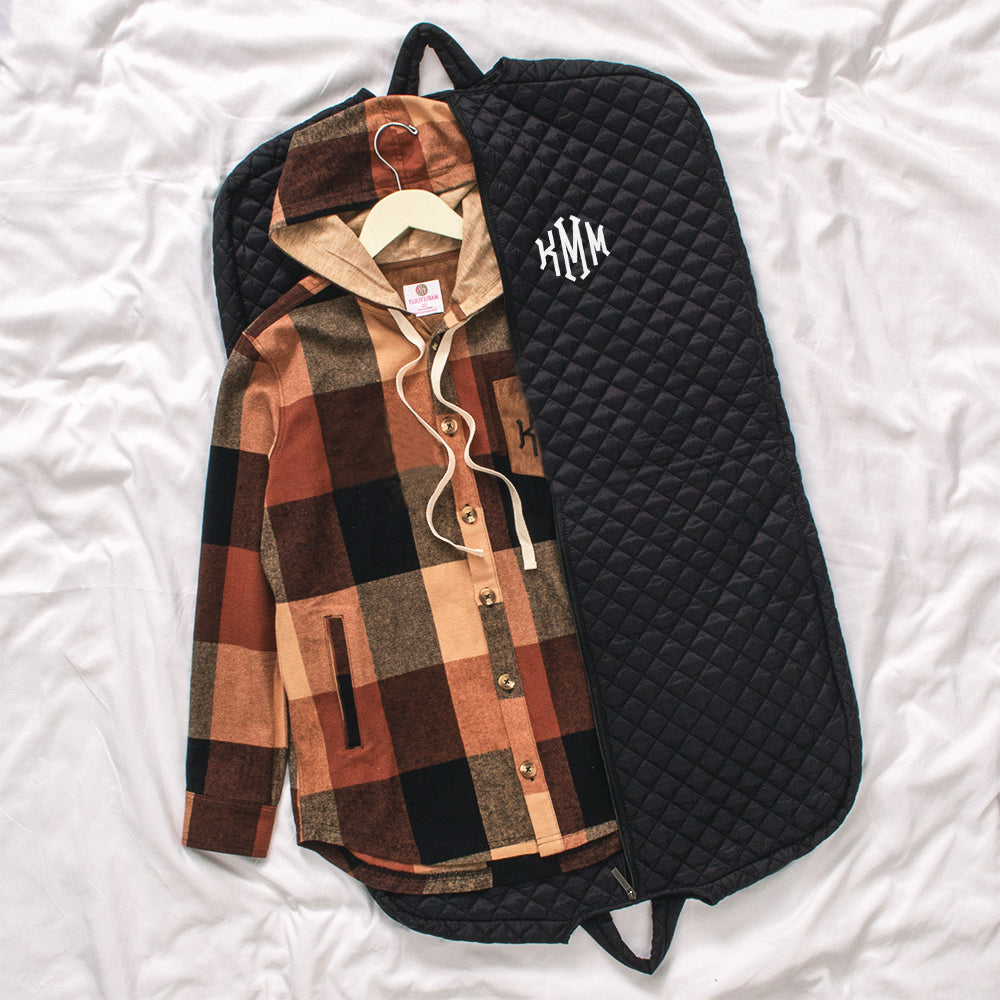 diamond quilted garment bag laying flat with shacket inside