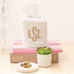 monogrammed tissue box on bedside table with books