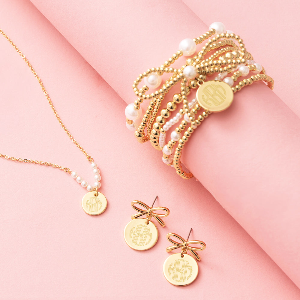 monogrammed pearl necklace bow earrings and pearl bow bracelet stack in gold