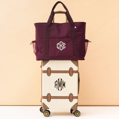 monogrammed carry on tote in burgundy on suitcase luggage