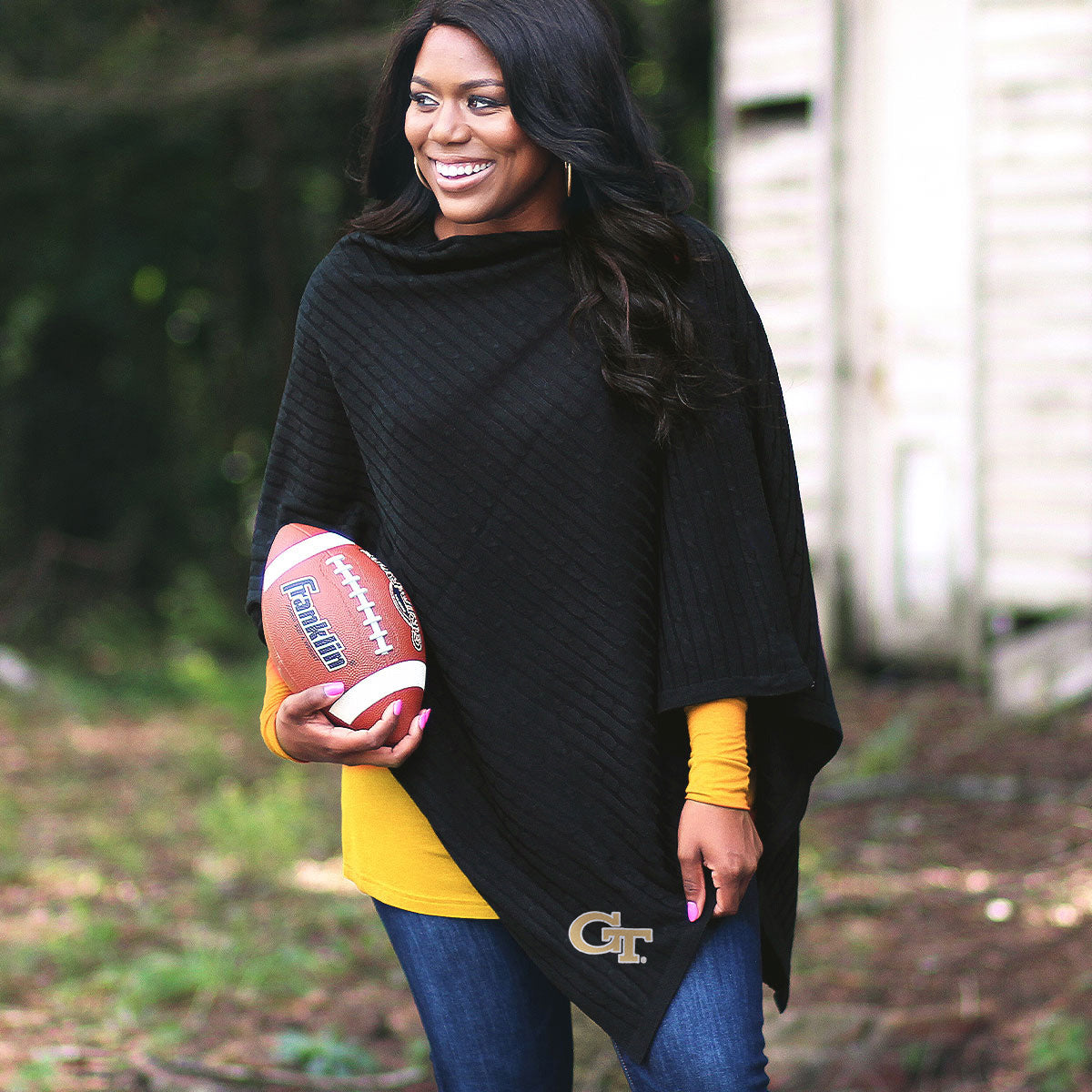 black ga tech poncho on girl holding football