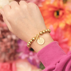 gold kids ball monogrammed bracelet on wrist