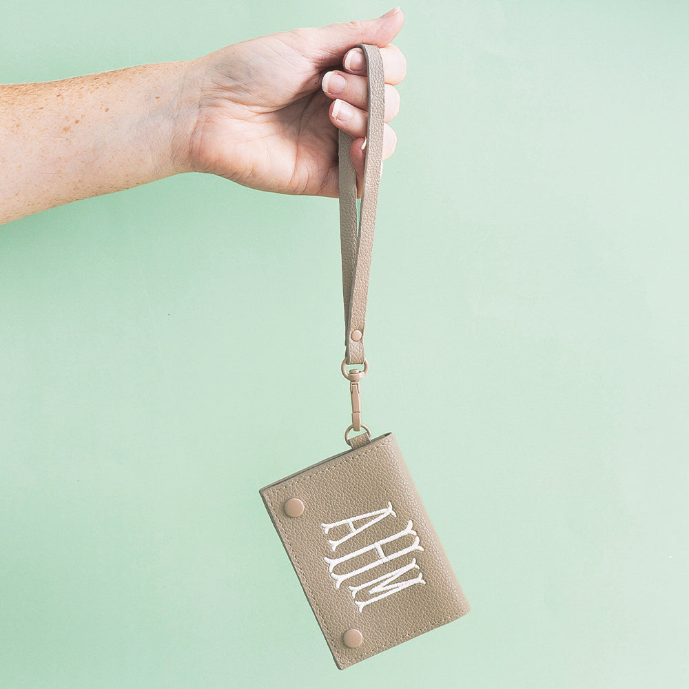 girl holding taupe monogrammed card holder wristlet