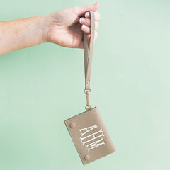 girl holding taupe monogrammed card holder wristlet