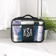 black monogrammed toiletry bag on counter
