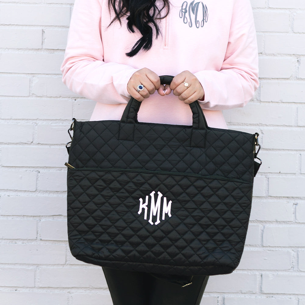 black quilted laptop bag in hands