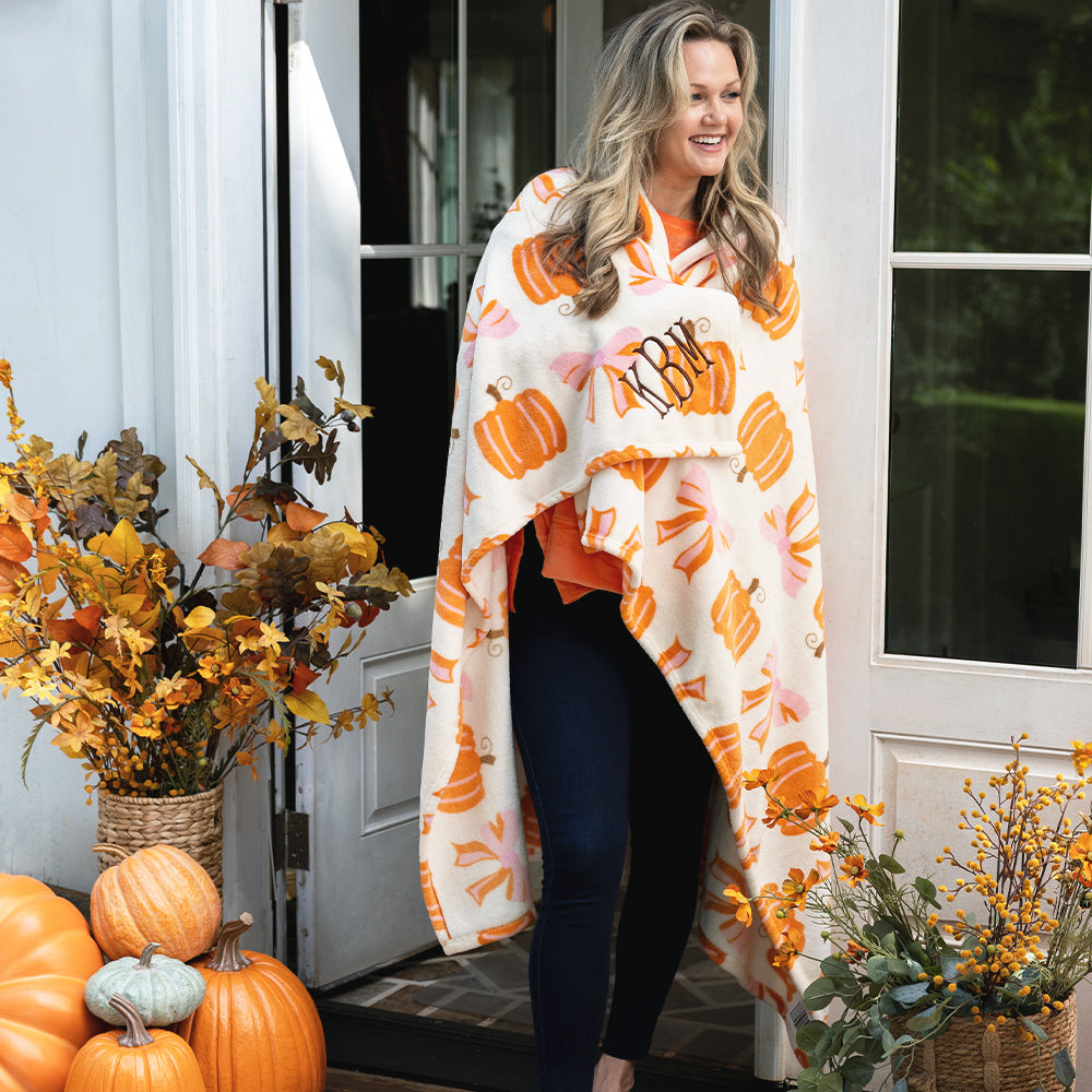 Posh Pumpkins blanket around girl on fall porch right