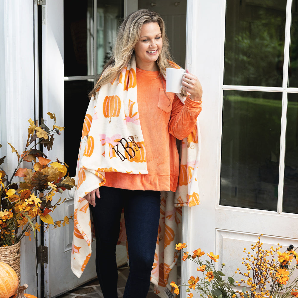 Posh Pumpkins blanket around girl on fall porch with coffee