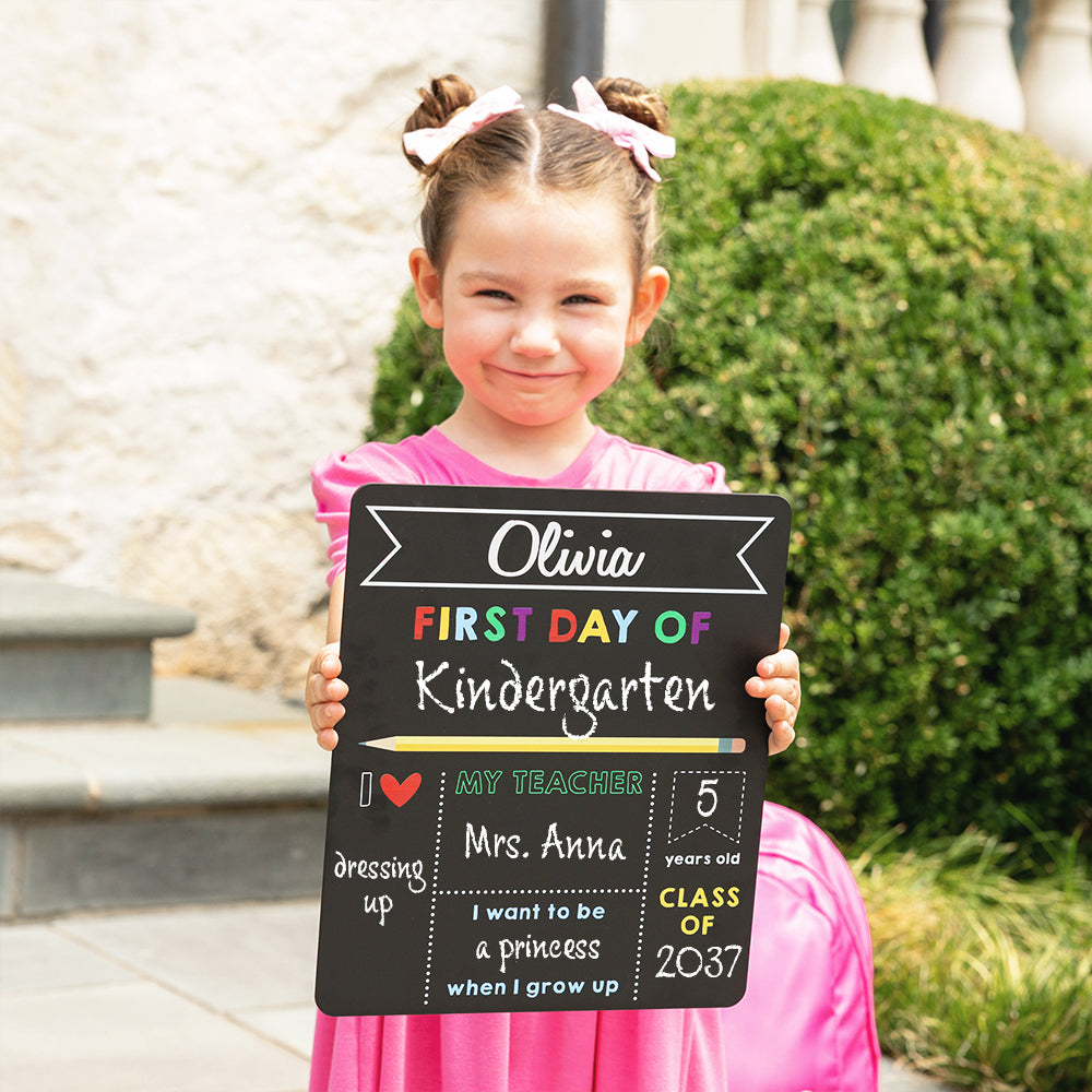 elle holding back to school chalkboard filled out