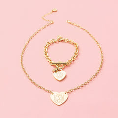 monogrammed heart bracelet and necklace in gold on pink