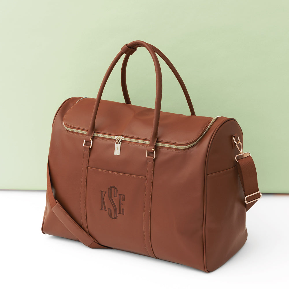 brown weekend travel bag on green background