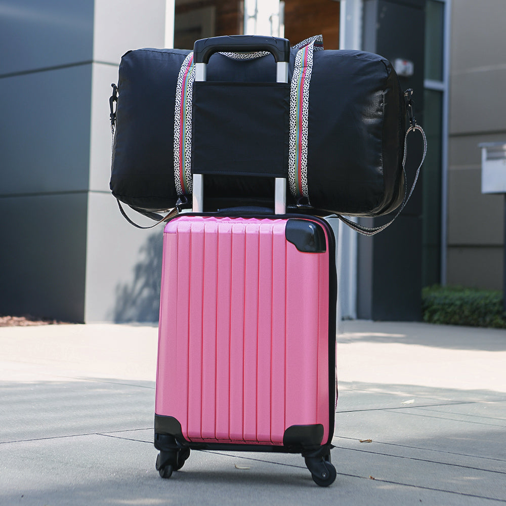 packable monogrammed black spottie duffle on pink luggage