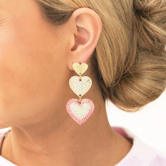 pink heart earrings in ear