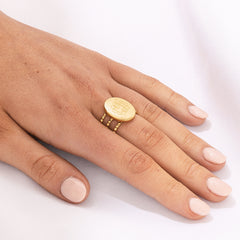 golden statement monogrammed ring on finger