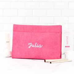 hot pink terry toiletry bag on bathroom counter