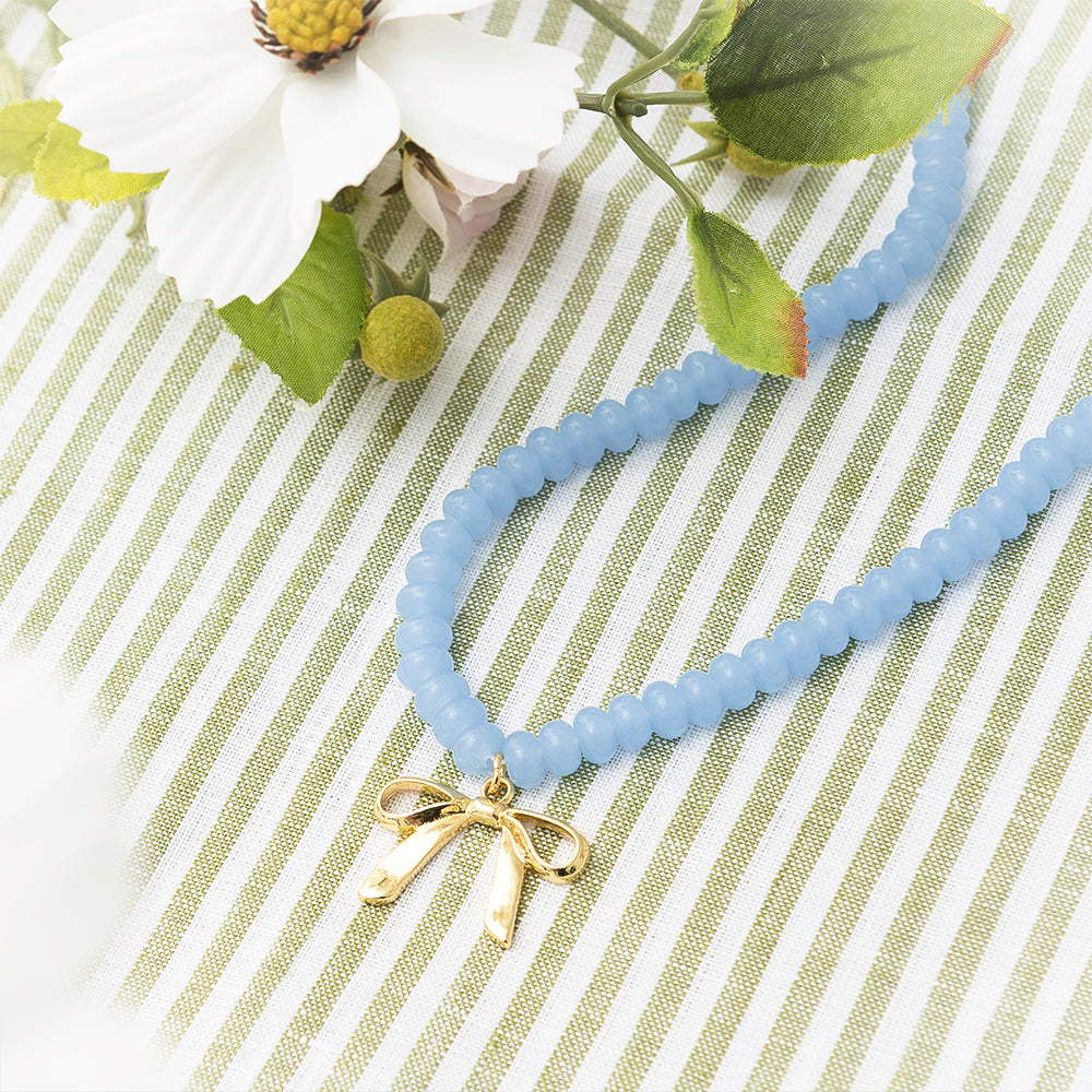 Beaded bow necklace on green
