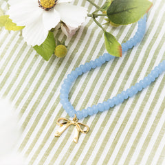 Beaded bow necklace on green