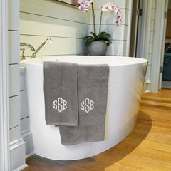 grey hand towel with grey bath towel on tub