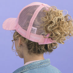 back of girl wearing pink camo trucker hat 